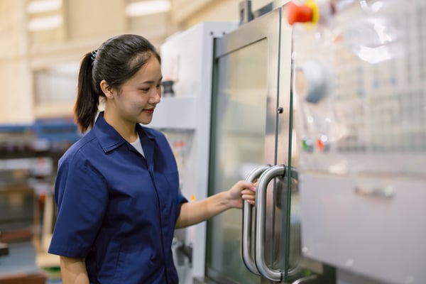 cnc machine operator next to equipment